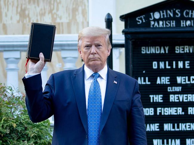 TOPSHOT - US President Donald Trump holds a Bible while visiting St. John's Church across from the White House after the area was cleared of people protesting the death of George Floyd June 1, 2020, in Washington, DC. - US President Donald Trump was due to make a televised address to the nation on Monday after days of anti-racism protests against police brutality that have erupted into violence. The White House announced that the president would make remarks imminently after he has been criticized for not publicly addressing in the crisis in recent days. (Photo by Brendan Smialowski / AFP)