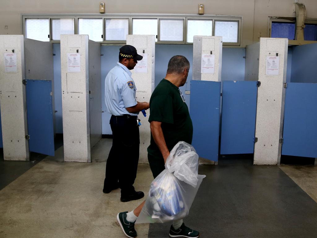 An inmate packs his possessions away in the processing centre in a clear plastic bag. Picture: Adam Taylor