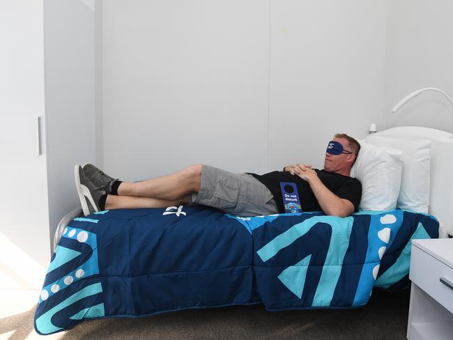 A journalist trys out a bed in athletes accommodation