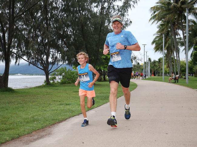 Keean Greven, 9, and his dad Peter Greven participate in the Cairns Regional Council's New Year's Eve superhero fun run on the Cairns Esplanade. Picture: Brendan Radke