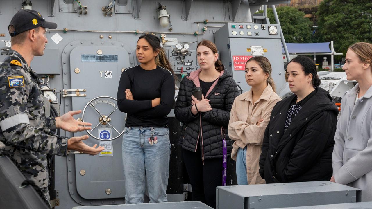 Clearance Diving Officer, Lieutenant Benjamin Morgan speaks with Defence Force Recruiting candidates during a tour on-board HMAS Gascoyne, alongside HMAS Waterhen, Sydney.