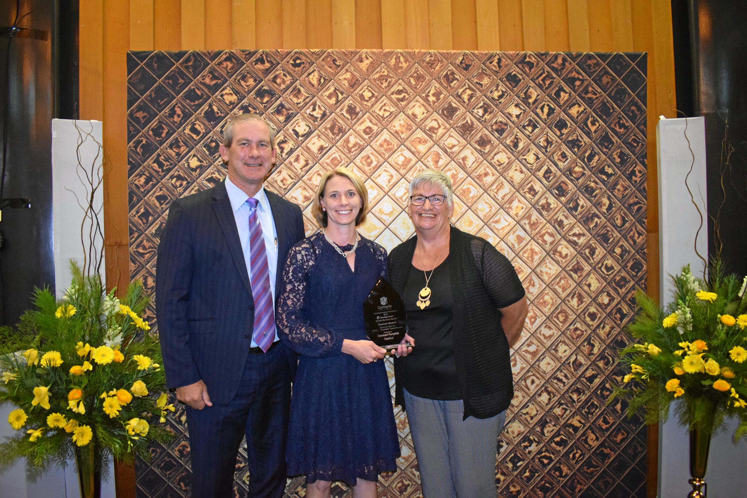 TOURISM AWARD: Mayor Mick Curran presents Emma Schneider and Kim Boyter from the Goomeri Pumpkin Festival with the Tourism Award on Saturday night. Picture: Scott Kovacevic