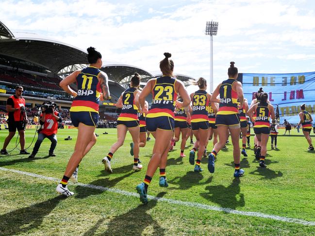 Adelaide players run through their banner before the start of the 2021 AFLW Grand Final. Picture: MARK BRAKE/GETTY IMAGES