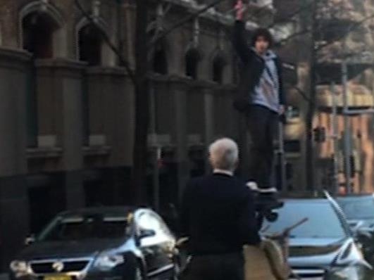 The man stands on a car as a member of the public approaches him armed only with a chair. Picture: Seven News