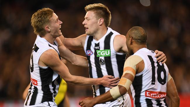 (L-R) Jaidyn Stephenson, Jordan de Goey and Travis Varcoe of the Magpies react after De Goey kicked a goal during the First Preliminary Final between the Richmond Tigers and the Collingwood Magpies in Week 3 of the AFL Finals Series at the MCG in Melbourne, Friday, September 21, 2018. (AAP Image/Julian Smith) NO ARCHIVING, EDITORIAL USE ONLY