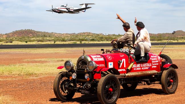 Matthew Benns and Warren Brown on board the Bean roadster wave to an RFDS plan. Picture: Nigel Wright