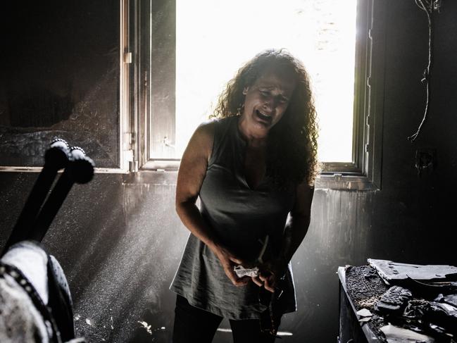 Kibbutz Nir Oz resident Hadas Kalderon, whose children have been taken hostage, and her mother and niece killed, breaks down in tears while looking through the burnt out home of her late mother Rina Sutzkever. Picture: Getty Images