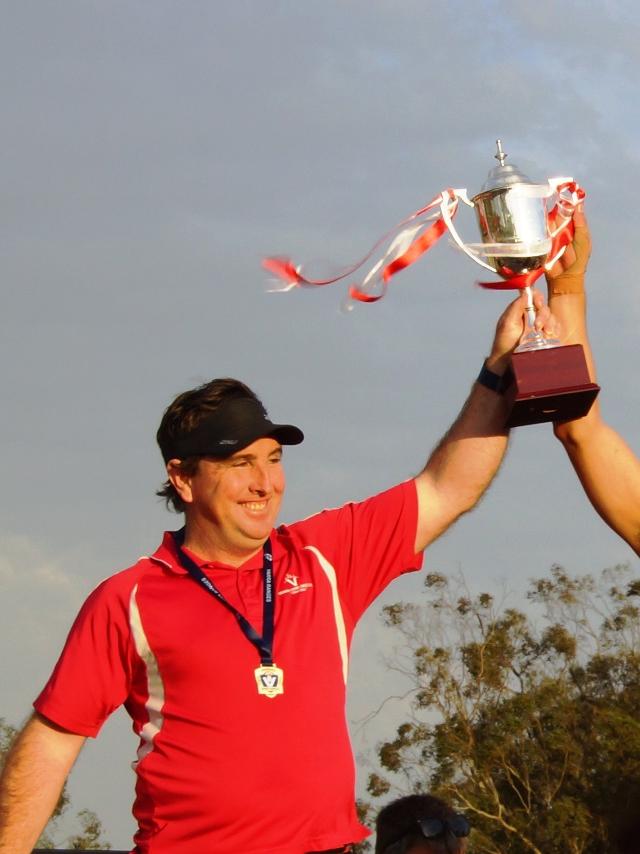 Donovan hoisting the cup with Olinda Ferny Creek.