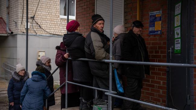 People queue outside a bank that closed during an air raid alert on January 21, 2025 in Izyum, Ukraine. Picture: Carl Court/Getty Images