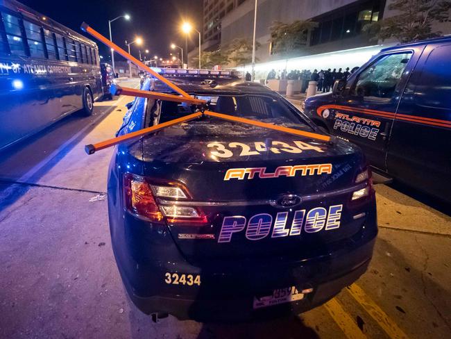 A police car is vandalised during rioting and protests in Atlanta over the death of George Floyd while under police custody. Picture: AFP