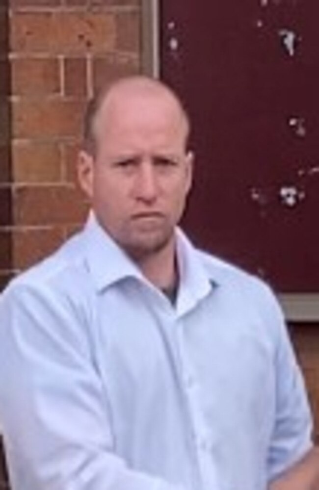 Andrew James Cougan, 37, of Gympie, is escorted from District Court after pleading guilty to charges including grievous bodily harm after hitting a woman so hard she suffered a brain injury which required surgery.