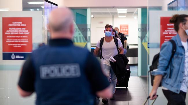 Passengers from an Adelaide-Darwin flight head towards buses that will take them to mandatory quarantine, after their plane landed at Darwin International Airport yesterday morning. Passengers were in the air when the decision was made. Picture: Che Chorley