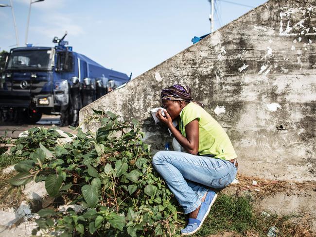 A Gabonese woman takes cover protecting her mouth from the tear gas as supporters of opposition leader Jean Ping protest, trying to reach the electoral commission, in Libreville on August 31, 2016.Picture: AFP PHOTO / MARCO LONGARI
