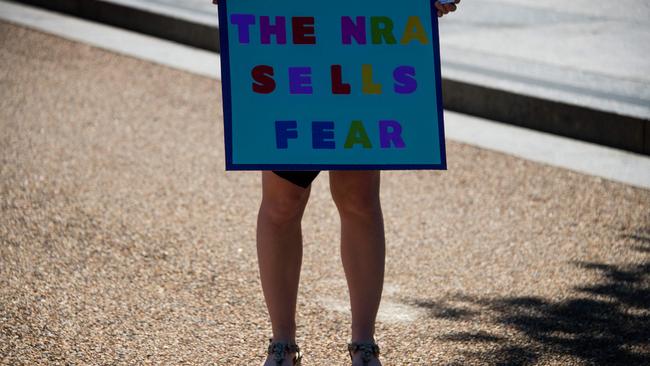 A demonstrator with ‘We The People For Sensible Gun Laws’ holds a placard as she and others protest outside the White House on July 11. Picture: AFP Photo/Jim Watson