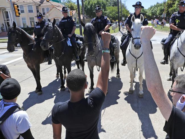 Protesters and police on horseback face each other during a demonstration outside a private event attended by President Donald Trump in Dallas. Picture: AP