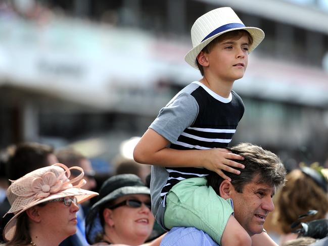 A young racegoer gets a high vantage point on the lawn at the 2014 Melbourne Cup. Picture: Jason Sammon