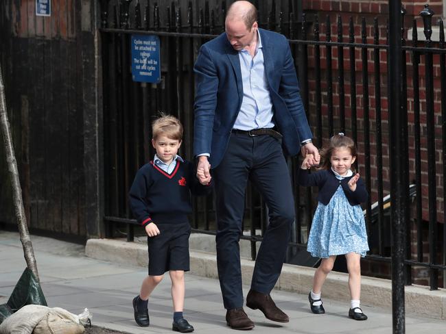 Princess Charlotte of Cambridge waves at the media as she is led in with her brother Prince George of Cambridge by their father Prince William to visit their newborn brother in hospital.