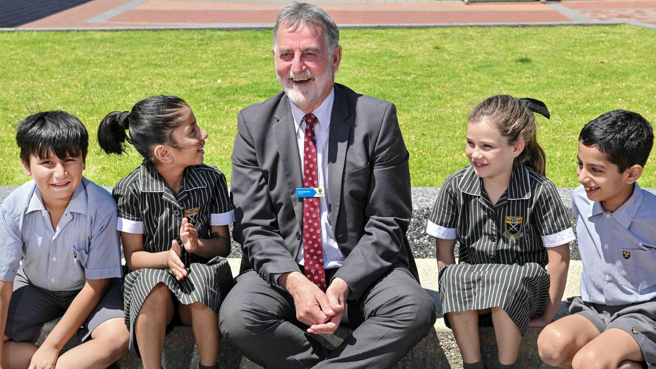 Former Port Adelaide SANFL player and chief executive Paul Belton is set to retire as principal of St Paul's College after more than 40 years in education. With year 2 students Carlos, Aishvir, Aria and Aarav. Picture: Brenton Edwards