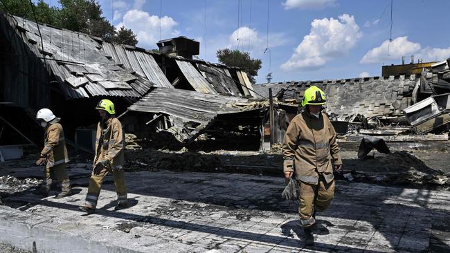 Rescuers walk in the destroyed Amstor mall in Kremenchuk, two days after it was hit by a Russian missile strike. (Photo by Genya SAVILOV / AFP)