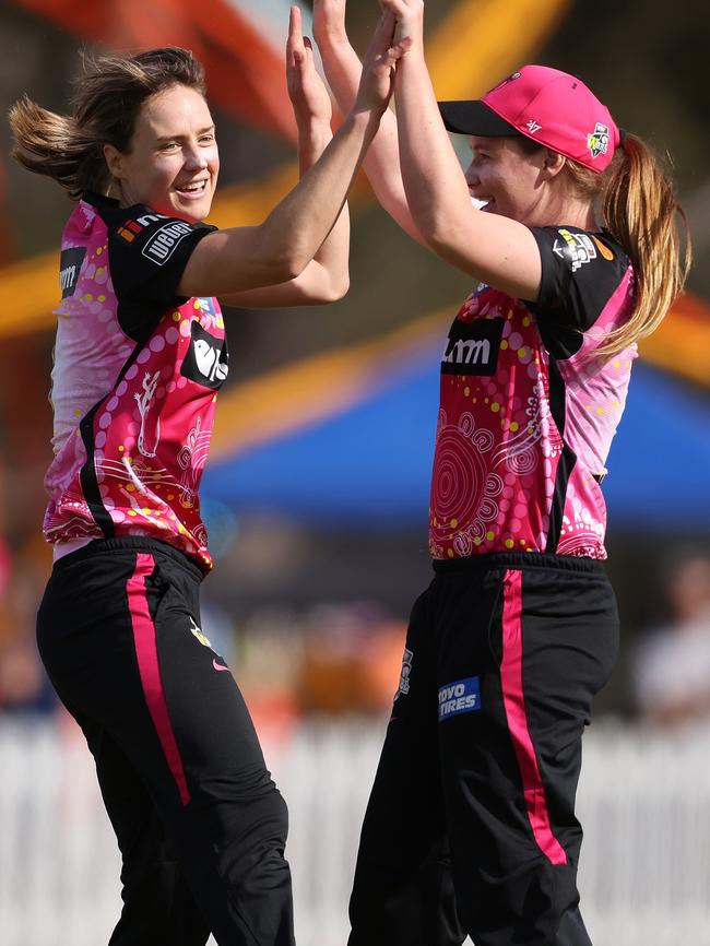 Cheatle, right, celebrates a wicket with Sixers captain Ellyse Perry during WBBL07. Picture: Paul Kane/Getty Images