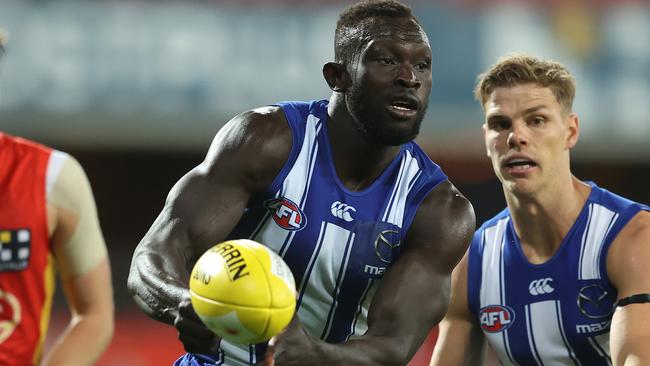 GOLD COAST, AUSTRALIA - AUGUST 30: Majak Daw of the Kangaroos handballs during the round 14 AFL match between the Gold Coast Suns and the North Melbourne Kangaroos at Metricon Stadium on August 30, 2020 in Gold Coast, Australia. (Photo by Chris Hyde/Getty Images)
