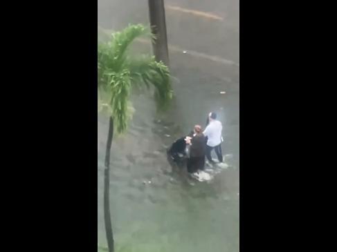 Parents take baby for a stroll through floodwater