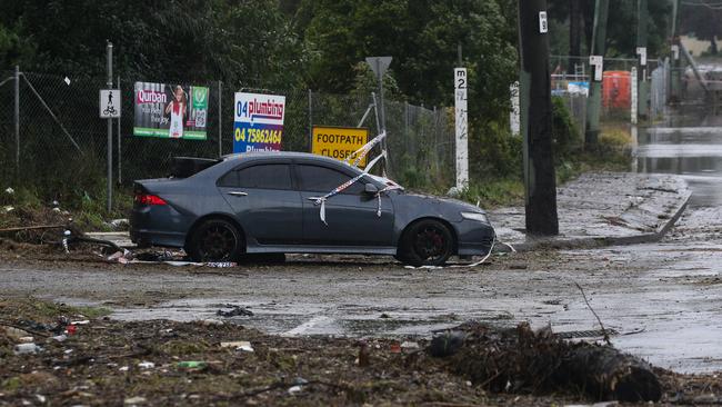 A damaged and abandoned car is seen taped off by the SES crew after being submerged in water yesterday at Chipping Norton. Picture: NCA Newswire / Gaye Gerard