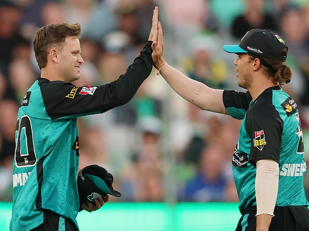 Matt Kuhnemann and Mitch Swepson celebrate the wicket of Melbourne Stars batter Sam Harper in the Heat’s first BBL win of season 14. Picture: Morgan Hancock/Getty Images