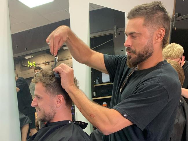 Movie star Zac Efron cutting Robby Lippett’s hair at Attaboy Barbers in Kent Town. Picture Supplied/Facebook.