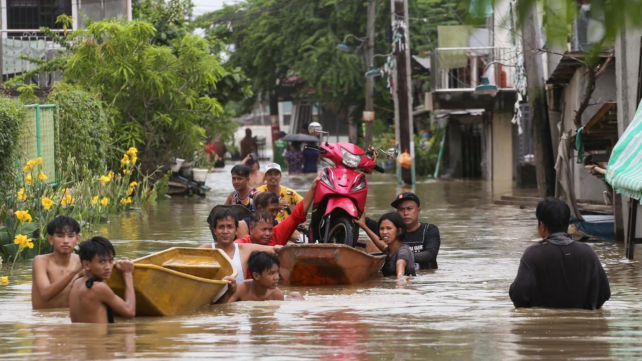 Residents transport a motorcycle on a boat to avoid floodwaters left by torrential rains of Typhoon Doksuri in Calumpit, Bulacan province on July 29, 2023. Picture: Earvin Perias / AFP