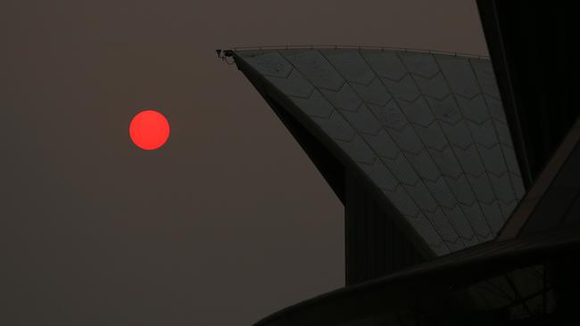 The sun is seen through bushfire haze next to the Sydney Opera House.