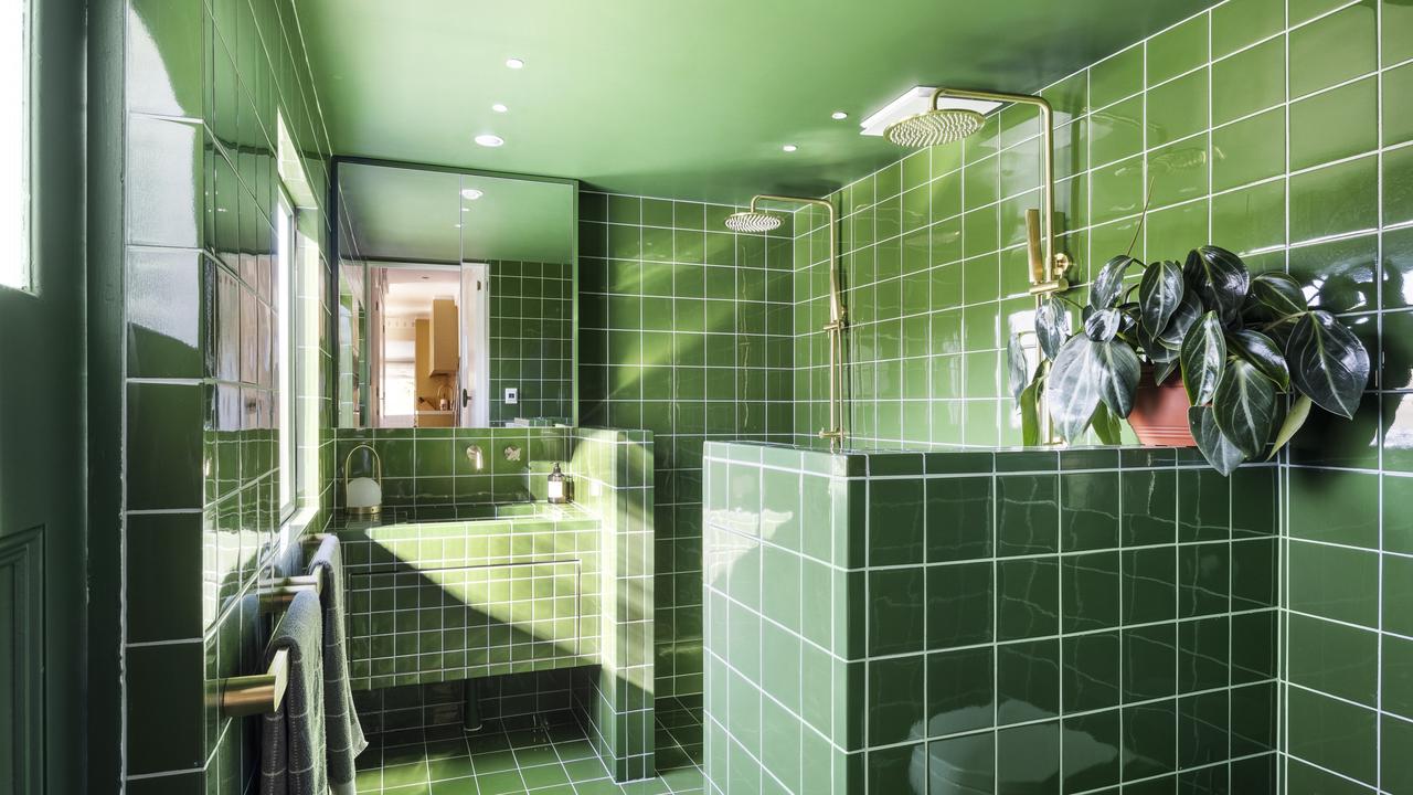 The bright green bathroom with a double shower head at 2/20 Cunningham St, South Yarra which Carrie and her partner renovated.