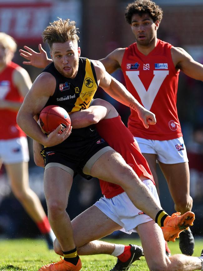 lenelg's Michael Virgin is caught in a strong tackle. Picture: Tom Huntley