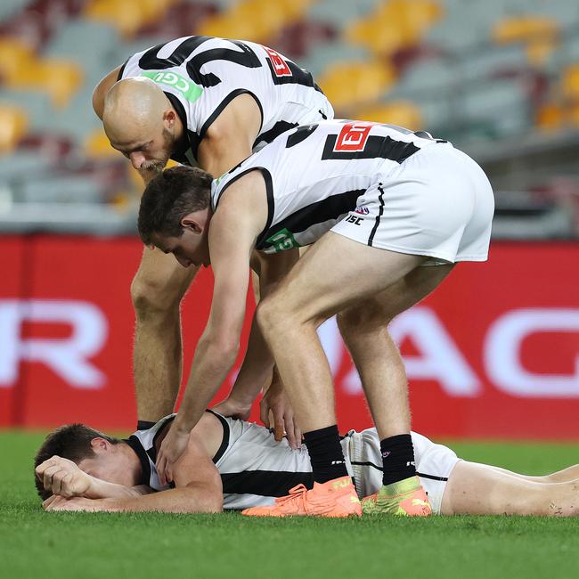 Brody Mihocek of the Magpies lies on the ground after he collided with Aaron vandenBerg. Picture: Michael Klein