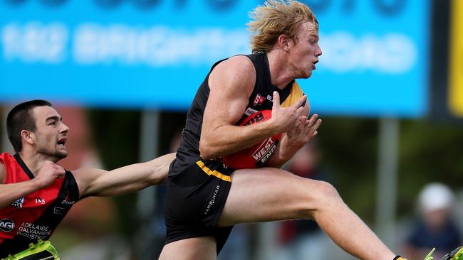 Glenelg’s Josh Scott marks in front of West Adelaide’s Brett Turner. Picture: Calum Robertson