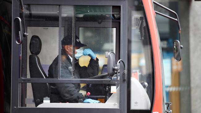 A bus driver wears a mask and gloves on his route along Auckland's Queen Street today. Picture: Getty Images