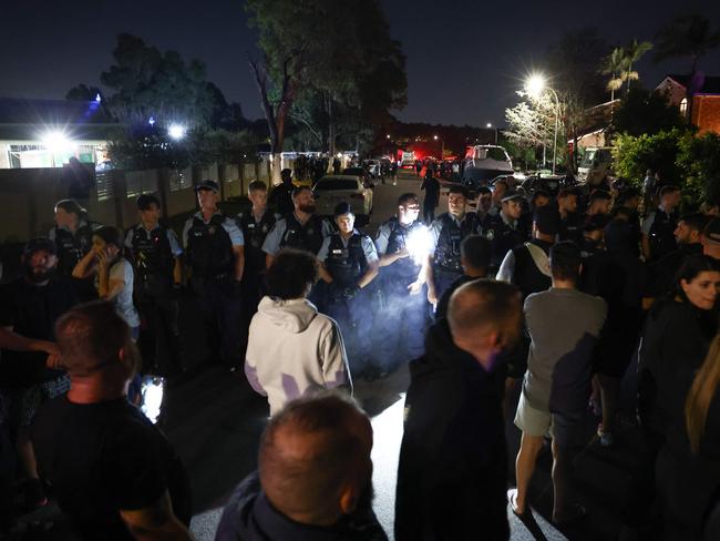 Locals gather with police guarding the perimeter of the Christ the Good Shepherd Church in Sydney's western suburb of Wakeley on April 15, 2024, after several people were stabbed in the church premises. Australian police arrested a man after several people were stabbed at a church in Sydney on April 15 and emergency services said four people were being treated for non-life threatening injuries. (Photo by DAVID GRAY / AFP)