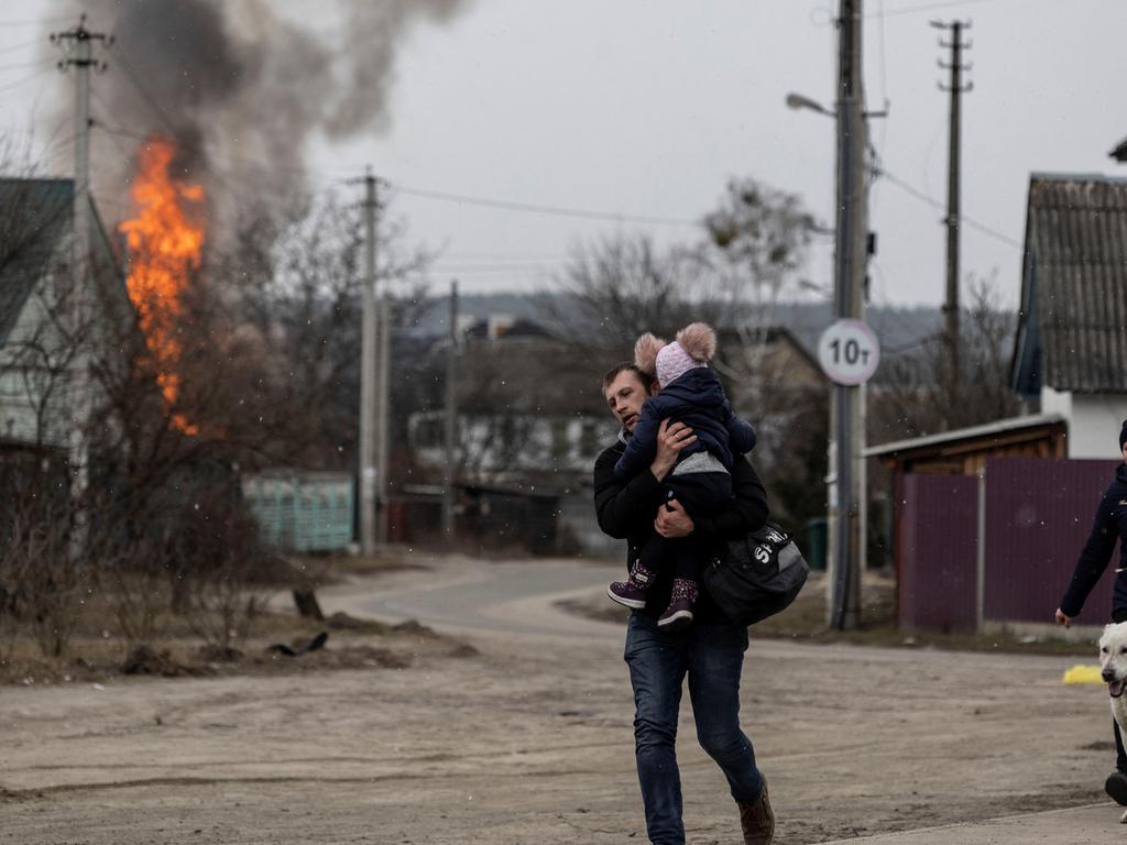 A man escapes the town of Irpin with his small child. Picture: Reuters