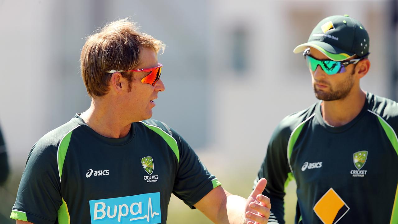 Shane Warne works alongside Nathan Lyon in 2014. Photo: Getty Images