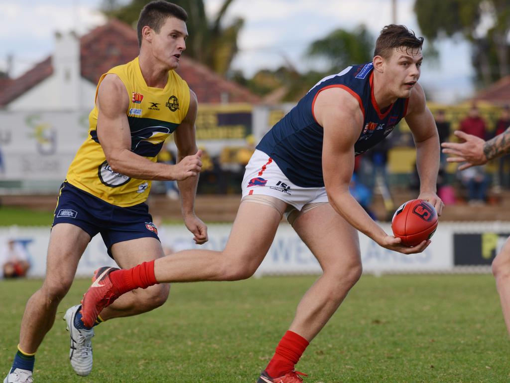 SANFL: Eagles v Norwood at Woodville Oval, Saturday, May 19, 2018. Norwood's Luke Surman gets a handball away, chased by Eagles Luke Thompson. (AAP Image/ Brenton Edwards)