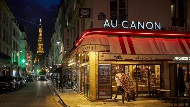 A bar owner closes up before the city-wide nightly curfew came into effect in Paris. Picture: Getty