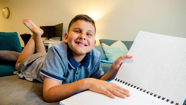 Aston Agostinho, 11, with his braille books. Braille House, which provides vital reading services, has bold plans for a new headquarters. Picture: Richard Walker