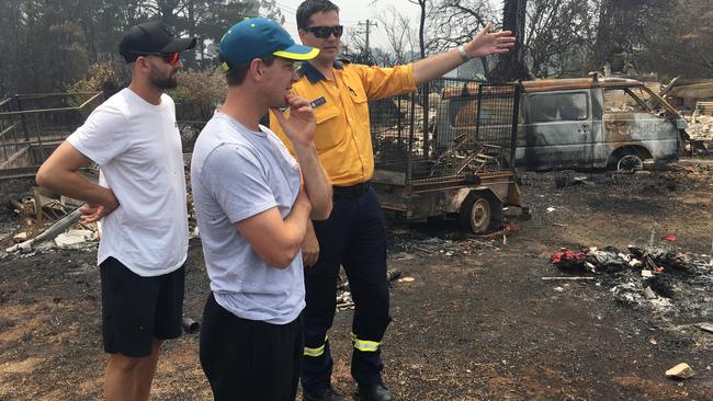 Paine and Lyon are shown the devastation at Wingello by a RFS volunteer.