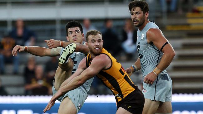 Matthew Kennedy gets a kick away under pressure from Tom Mitchell during the JLT Cup. Picture: Chris Kidd