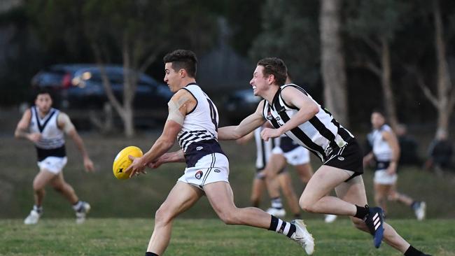 Bundoora midfielder Nathan Thomas tries without luck to evade a tackle. Picture: James Ross.