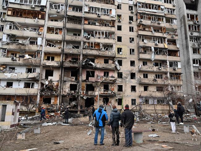 People look at a damaged residential building at Koshytsa Street after it was struck by missile fragments. Picture: AFP.