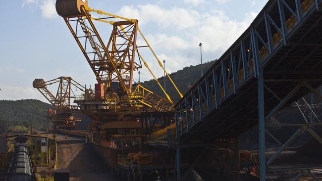 Crushed iron ore fills cargo train wagons aside a conveyor belt at Vale's iron ore Brucutu mine. Picture: Dado Galdieri.