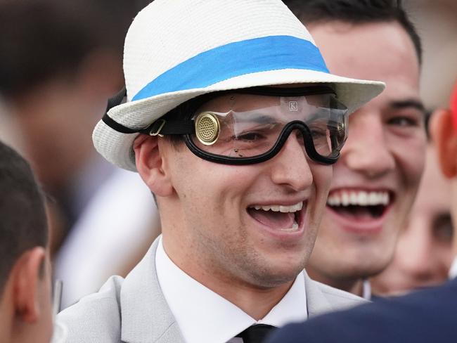 A racegoers is seen wearing the goggles thrown to him by Jockey Dwayne Dunn after riding Tofane to victory in race 9, the Furphy Sprint during Derby Day at Flemington Racecourse in Melbourne, Saturday, November 2, 2019. (AAP Image/Michael Dodge) NO ARCHIVING