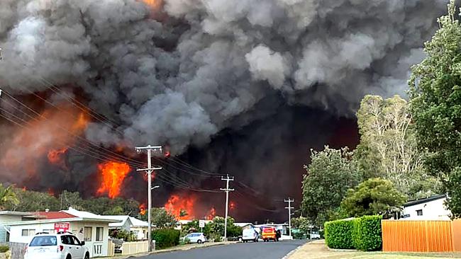 A huge fire approaches Harrington north east of Sydney on Friday evening.