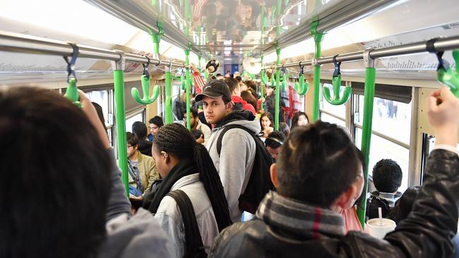 Passengers ride a crowded tram through Swanston Street in Mlebourne's CBD. Picture: Jake Nowakowski